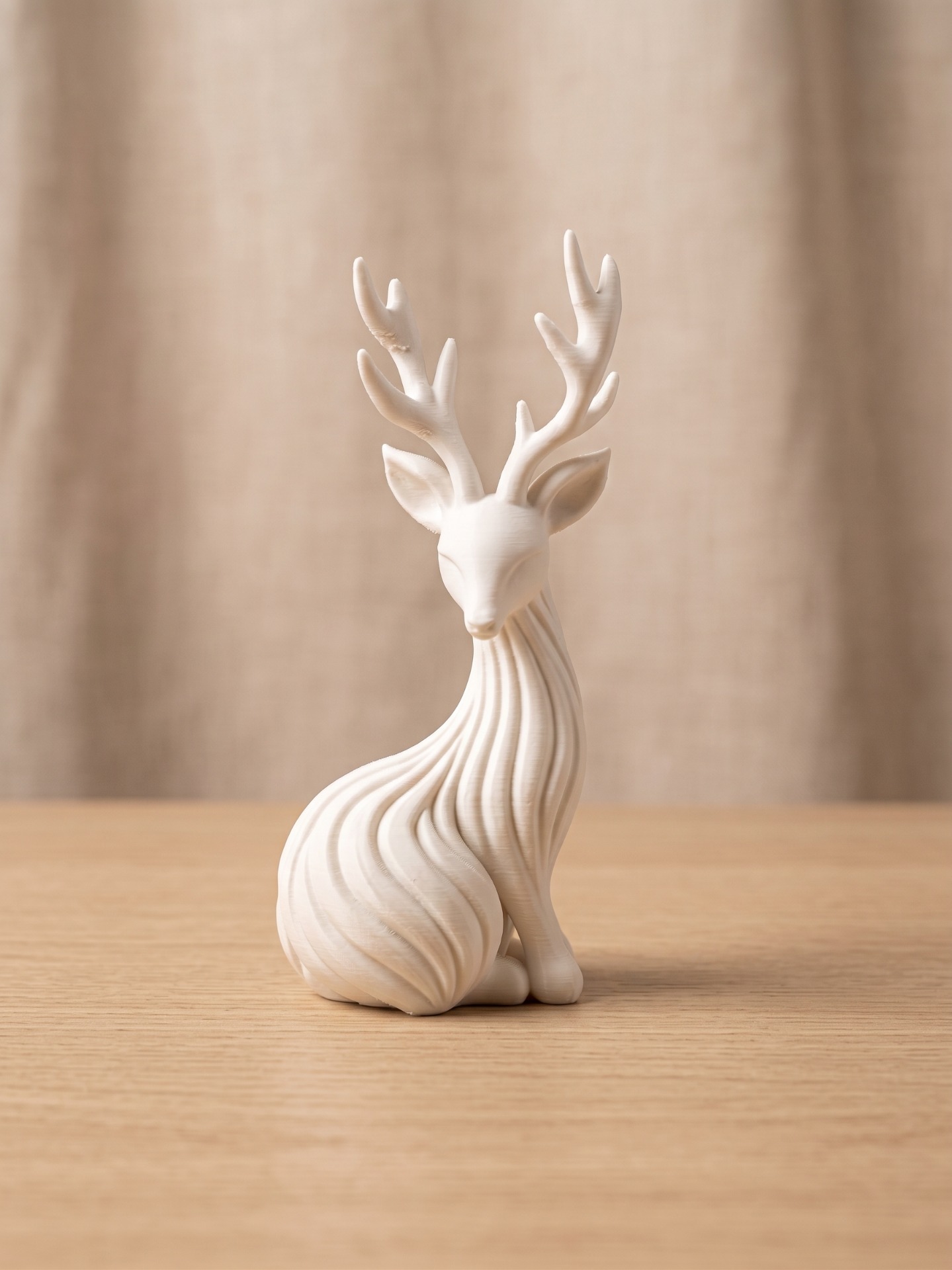 Witte hertenbeeldje met gewei omhoog, op houten plank, zachte beige achtergrond en warm licht.